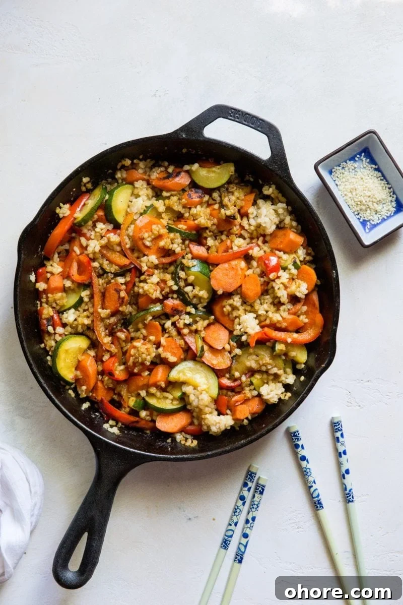 Teriyaki Veggie Stir-Fry with Jasmine Rice 5 Teriyaki Stir Fry Vegetables with Rice in a cast iron skillet with two sets of chop sticks to the side.