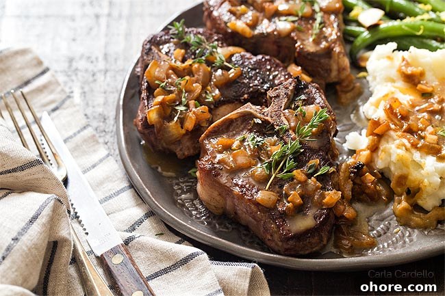 Fried lamb chops on plate with pan sauce