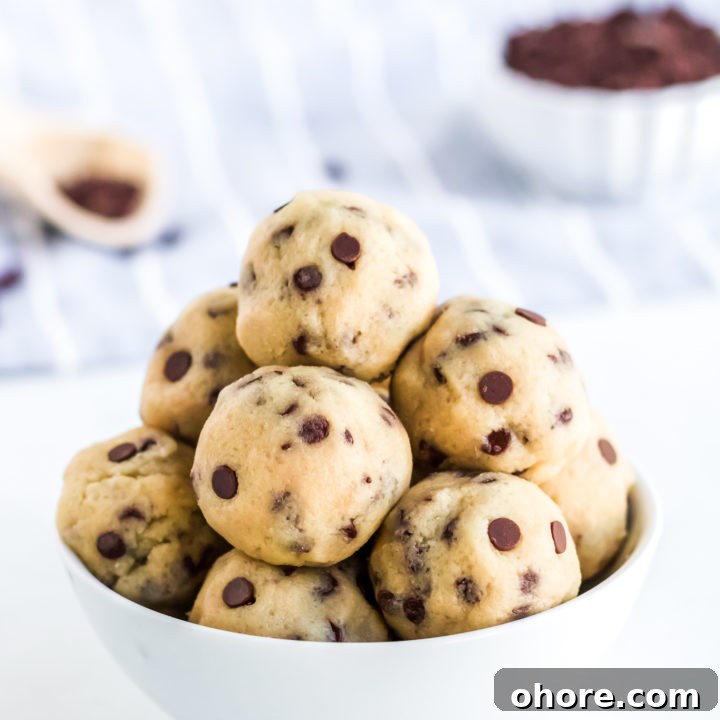 cookie dough balls in a white bowl with chocolate chips in the background