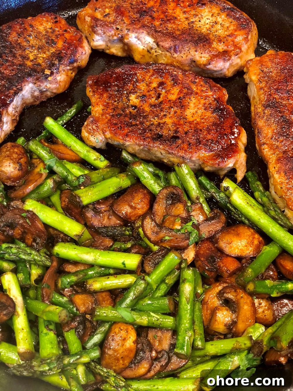 Pork chops and veggies in a cast iron skillet