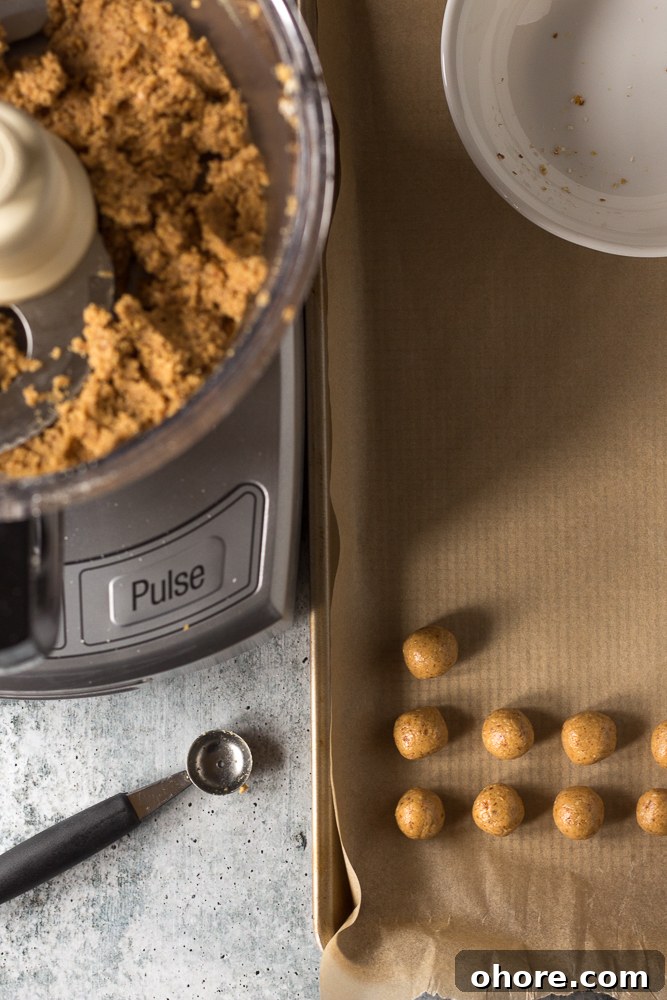 Vegan Peanut Butter Chocolate Truffles: No-Bake Snack Recipe 5 Vegan Peanut Butter balls rolled on parchment lined baking sheet by Flora & Vino
