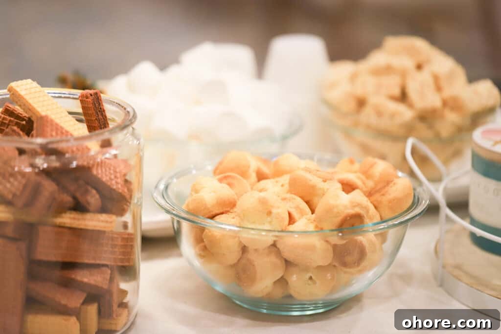 How to Choose the Perfect Chocolate Fountain for Your Event 5 A table with separate bowls filled with items for dipping into a chocolate fountain, including wafer cookies, cream puffs and marshmallows.