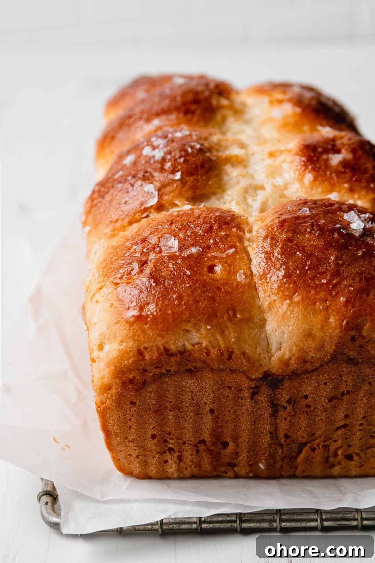 Soft Gluten-Free Dinner Rolls Recipe — Classic Homemade Rolls 9 Baked golden brown gluten free dinner rolls on parchment and wire rack.