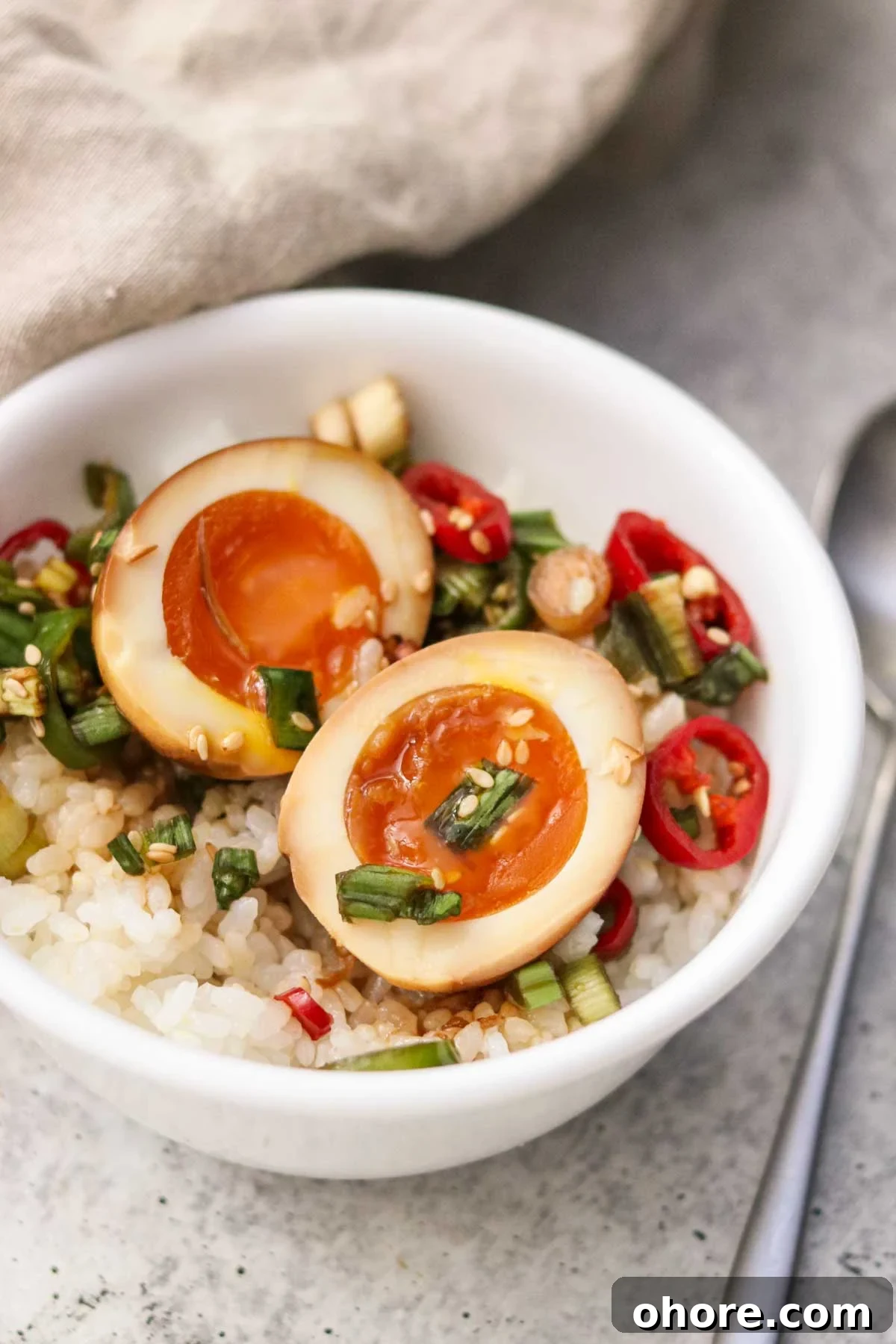 A sliced Mayak egg served over rice in a bowl