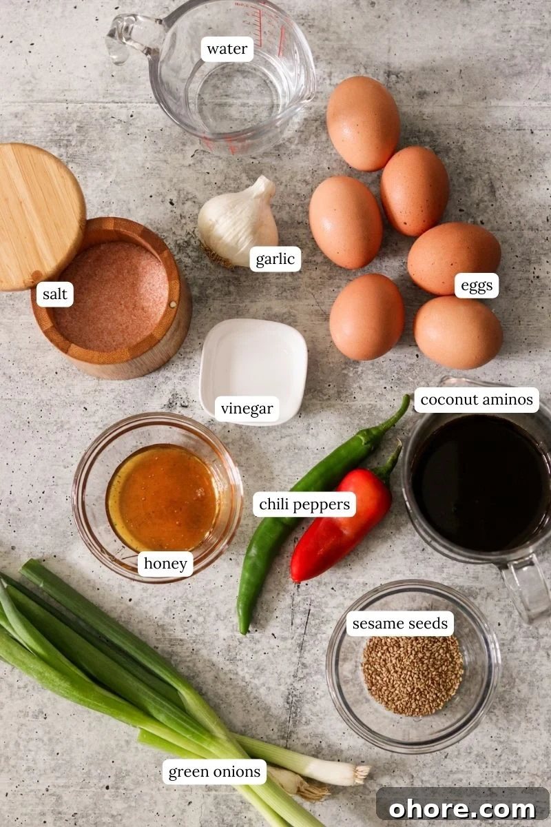 mayak eggs ingredients on a counter including honey, sesame seeds, coconut aminos, greens onions, chili peppers, salt, garlic, vinegar, and eggs. 