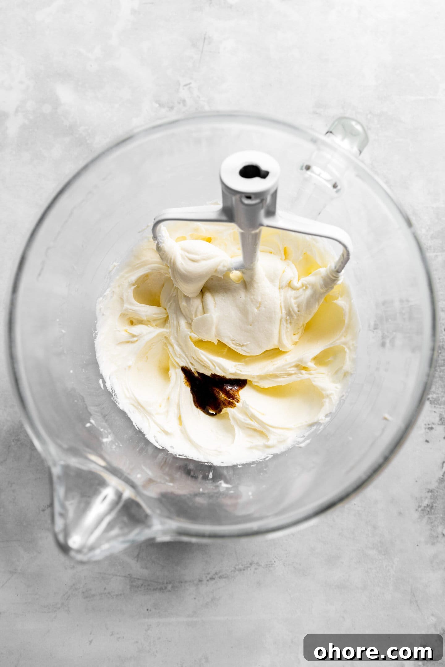 Cream Cheese Frosting with 5 Simple Ingredients 5 Vanilla bean paste being added to cream cheese frosting.