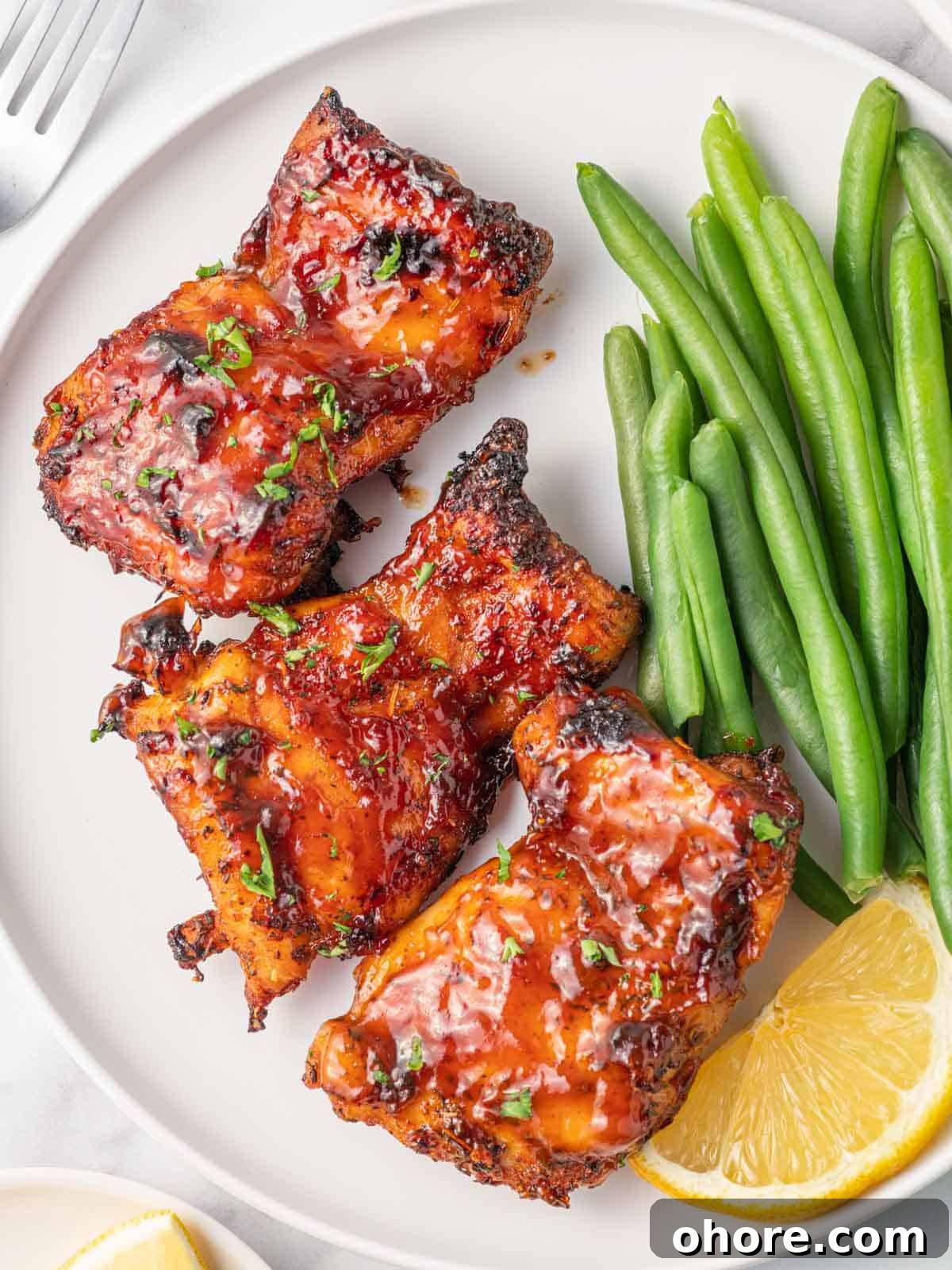 Crispy Air Fryer BBQ Chicken Recipe for Juicy, Quick Dinners 8 Best air fryer chicken thighs on a plate with green beans.