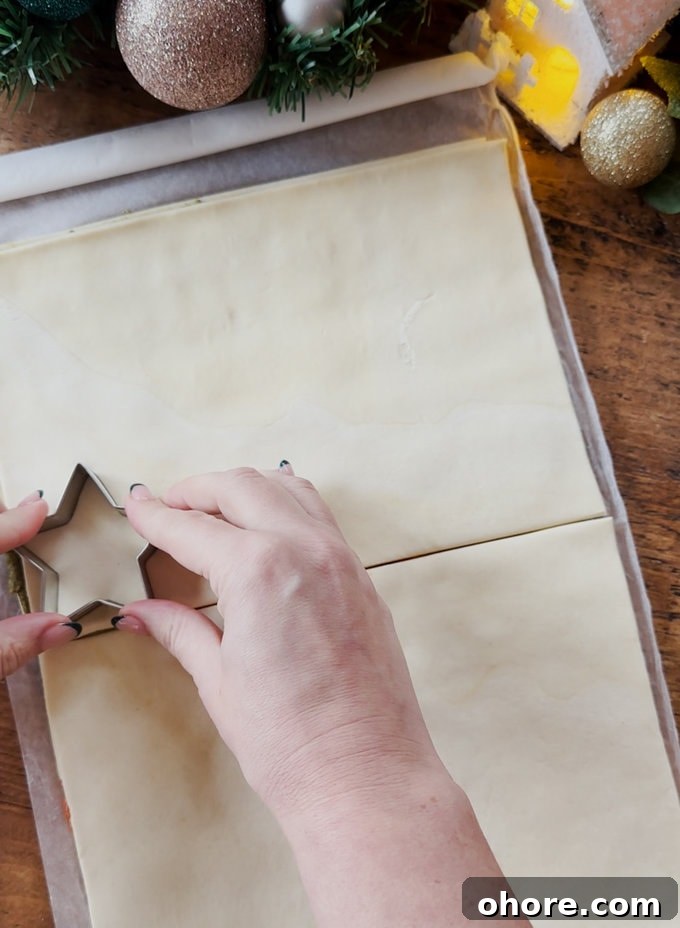 Pesto Puff Pastry Star Wreath Recipe for Holiday Appetizers 6 Star shapes being cut out of the pastry using a star shaped pastry cutter.