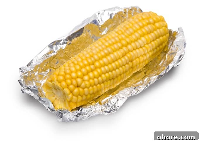 Corn on the cob wrapped in a piece of aluminum foil.