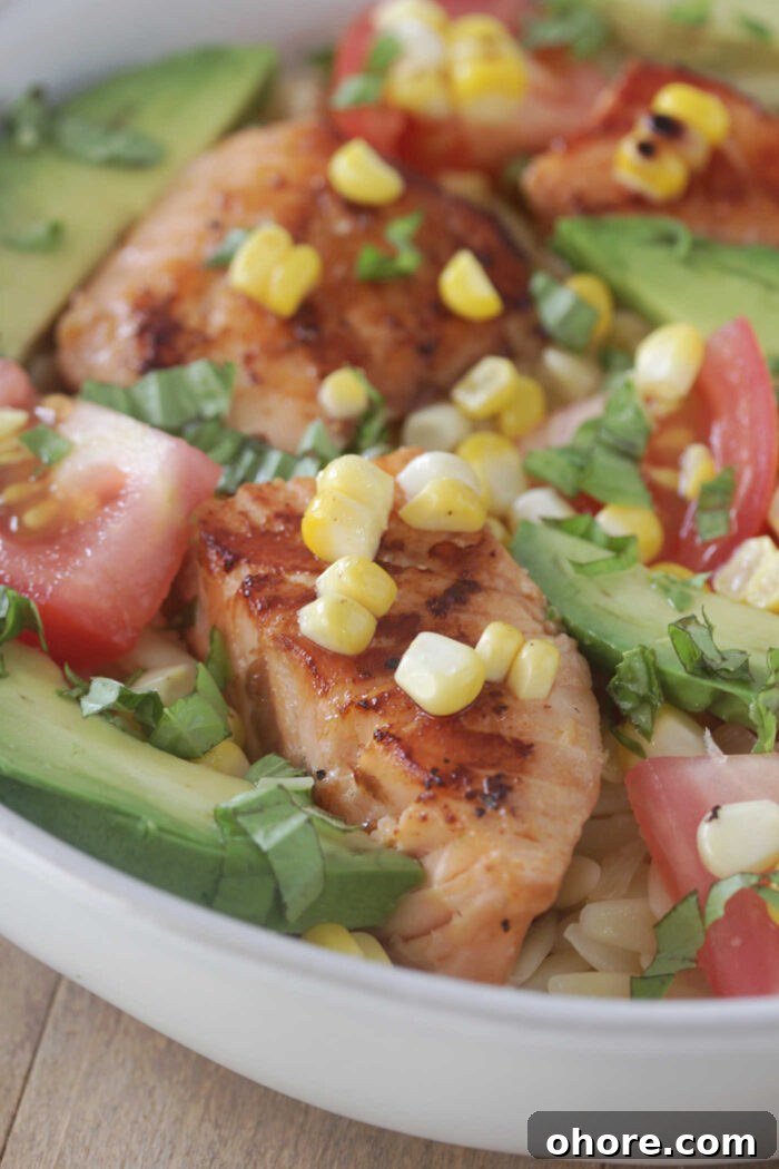 Close-up shot of grilled salmon with orzo and corn
