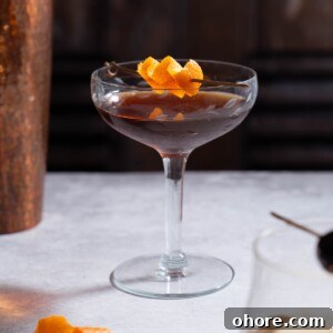 Nocino Negroni: A Dark Twist on the Manhattan Cocktail 7 A Nocino Black Manhattan cocktail garnished with orange peel