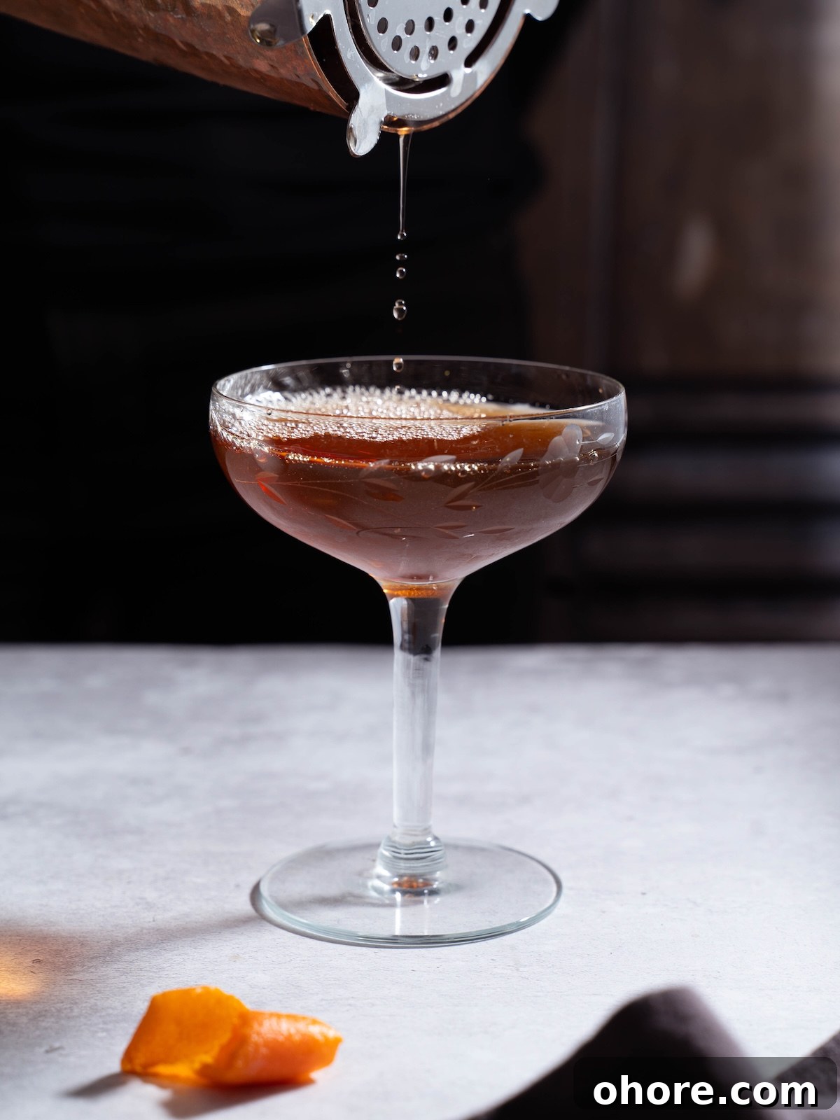 Nocino Negroni: A Dark Twist on the Manhattan Cocktail 4 Pouring a Black Manhatten out of a cocktail shaker