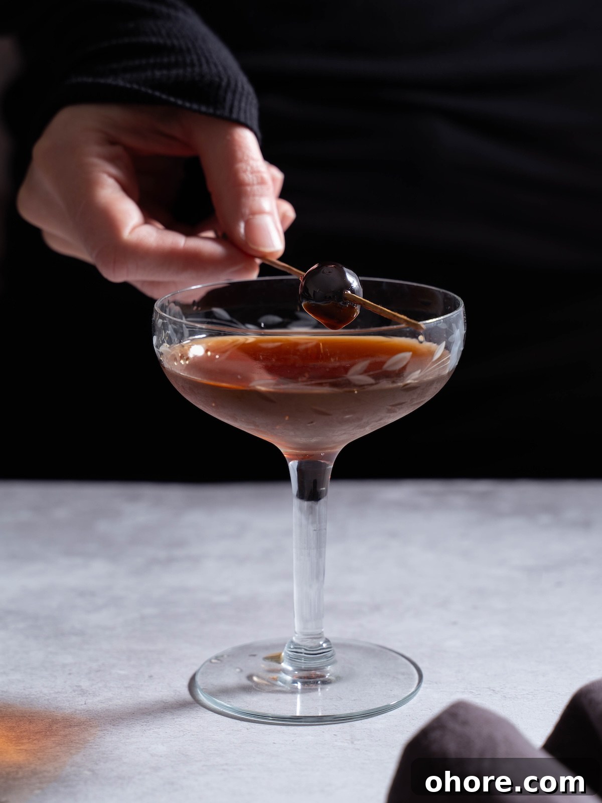 Nocino Negroni: A Dark Twist on the Manhattan Cocktail 5 Adding a cherry garnish to a cocktail