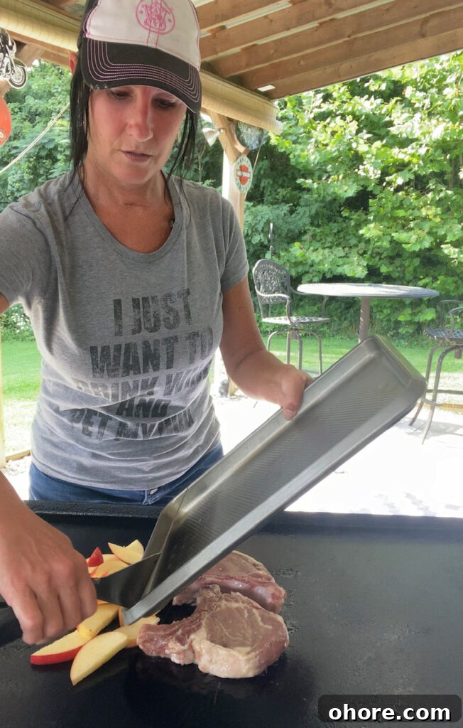 Apple-Brined Pork Chops on the Blackstone Grill 5 adding pork and apples to the griddle