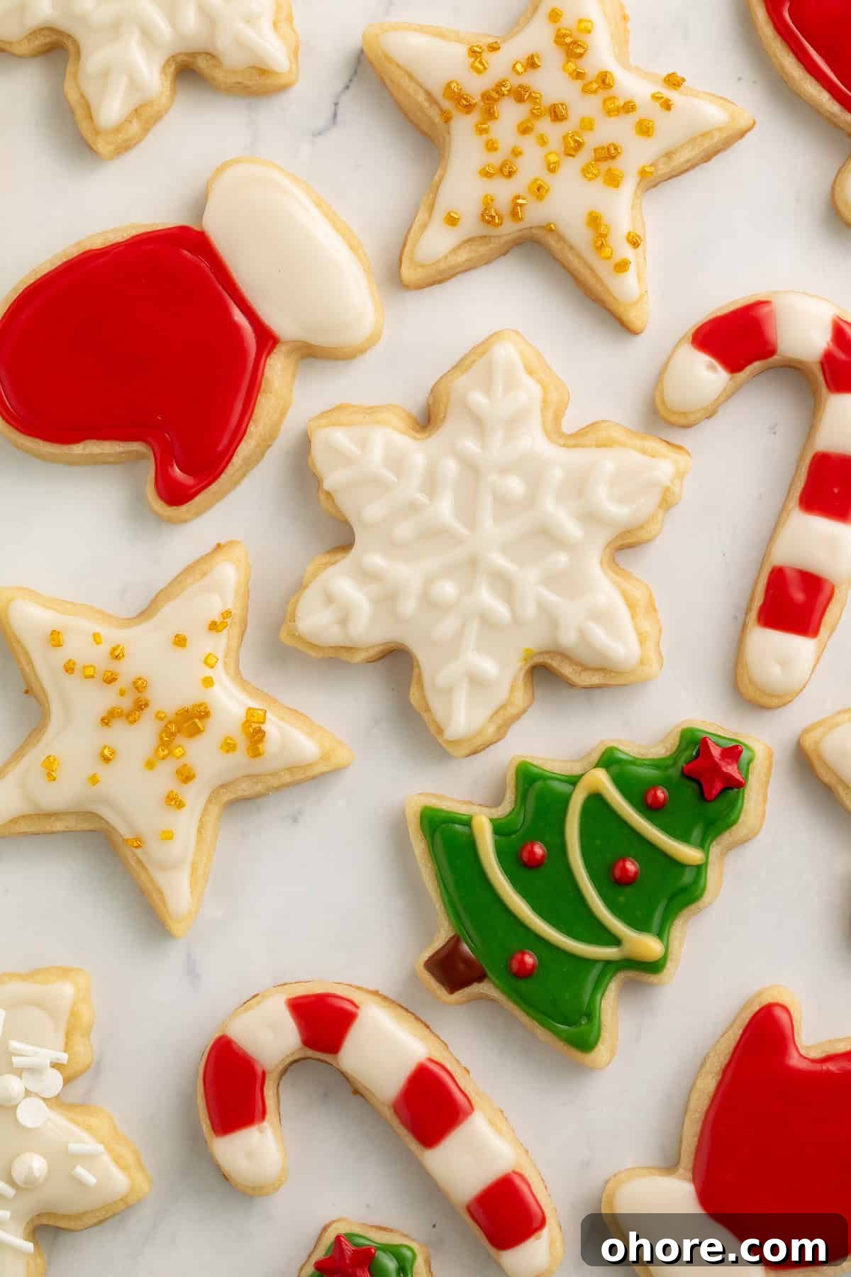 Vegan Christmas Cookie Recipes for Holiday Baking 2 Christmas cookies decorated as a star, a snowflake, a tree, candy canes, gloves and a pair of mittens.