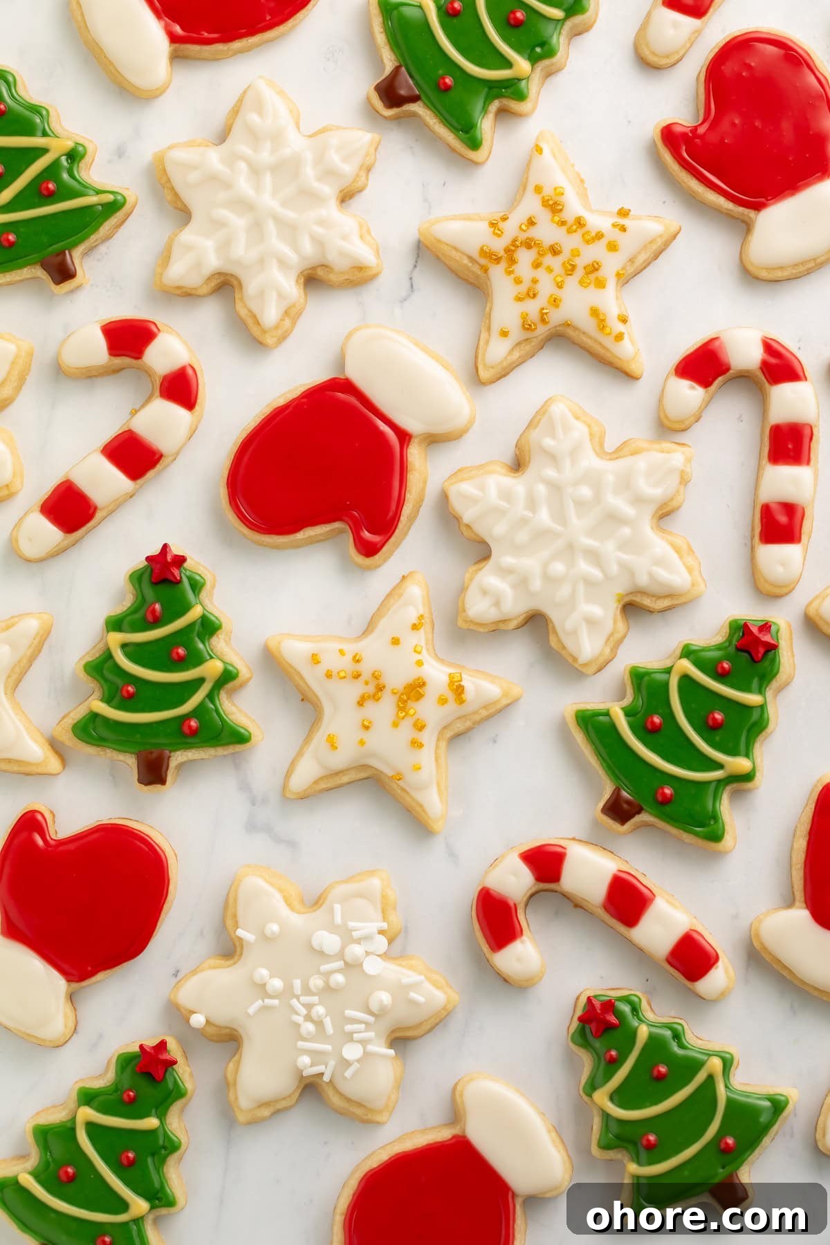 Vegan Christmas Cookie Recipes for Holiday Baking 3 Various vegan decorated Christmas cookies on a white marble background.