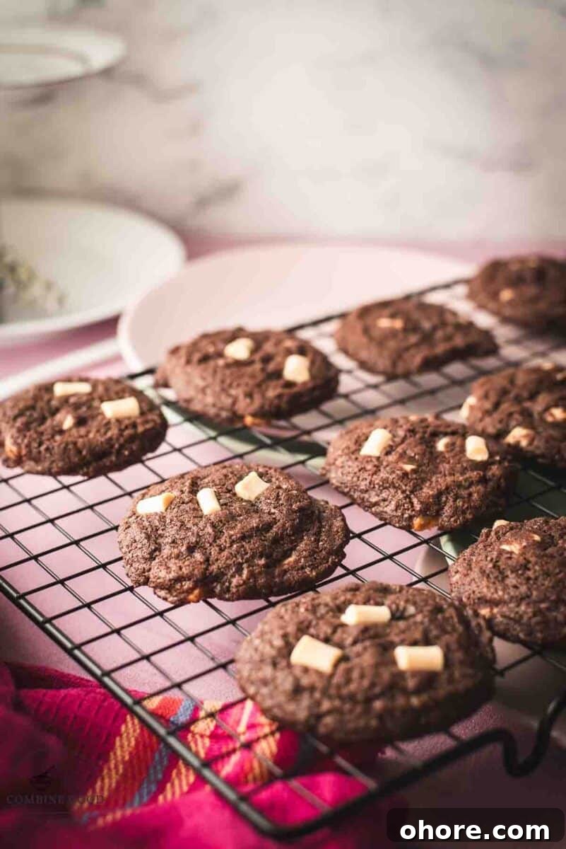 Divine white chocolate chip cookies with an incredible dark chocolate dough. Placed on a cooling rack.