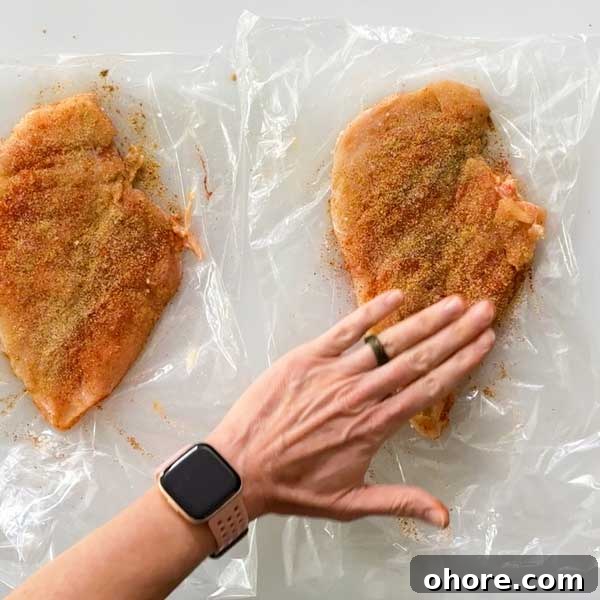 Stovetop Dutch Oven Shredded Chicken Recipe 5 Seasoning chicken on a cutting board.