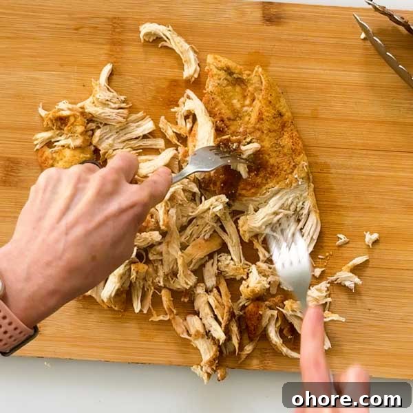 Stovetop Dutch Oven Shredded Chicken Recipe 7 Shredding chicken with two forks.