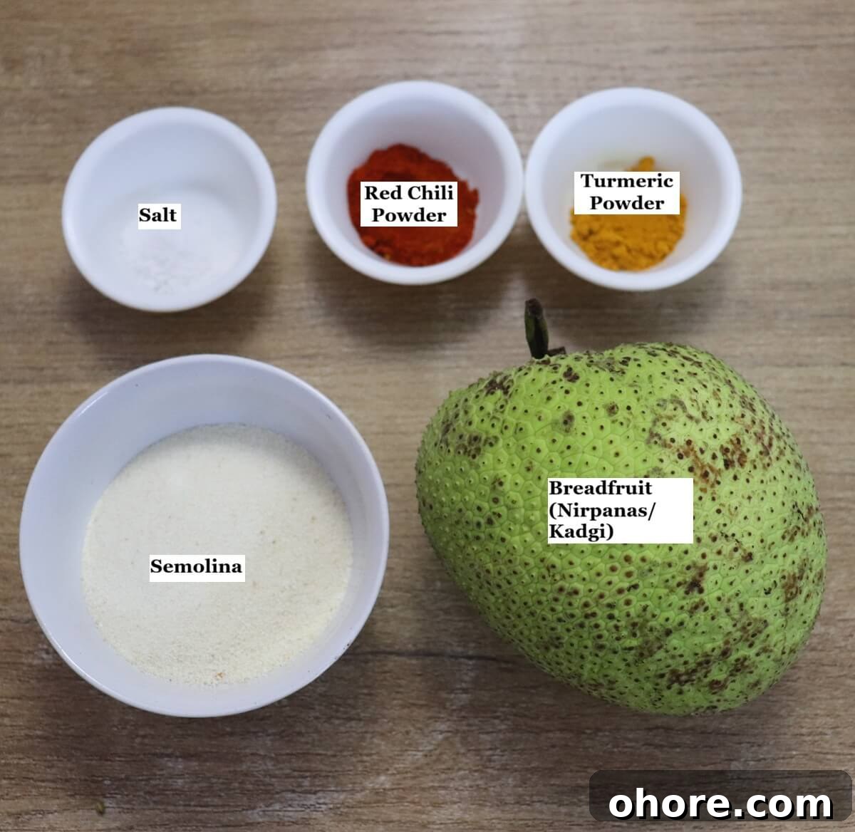 Crispy Breadfruit Fry (Nirpanas/Kadgi) Recipe 4 individually labelled ingredients to make breadfruit fry or nirpanas fry are laid out on a table.