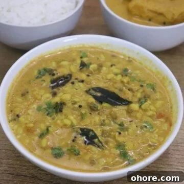 mooga gathi also known as sprouted green gram curry served in a white bowl.