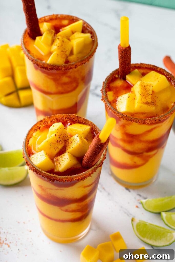 Top view of a glass with mangonada topped with tajin and mango chunks