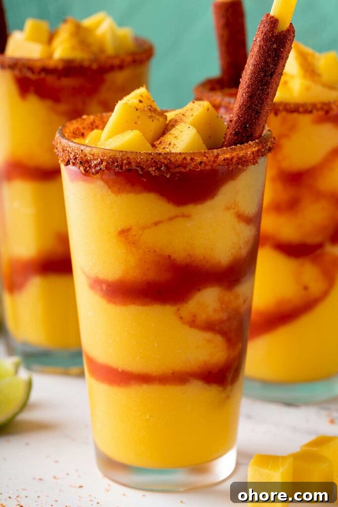 Closeup of a mangonada frozen drink in a glass with a candy tamarind straw