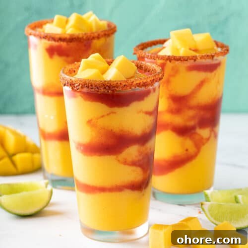 Three glasses filled with frozen mocktail made from mango and layered with spicy Mexican sauce.