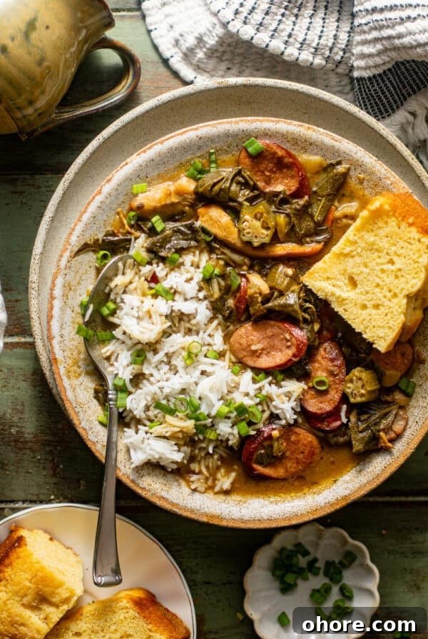 Cajun Shrimp and Creamy Cheddar Grits Recipe 12 overhead photo of gumbo greens in a bowl with cornbread and rice garnished with chopped green onions.