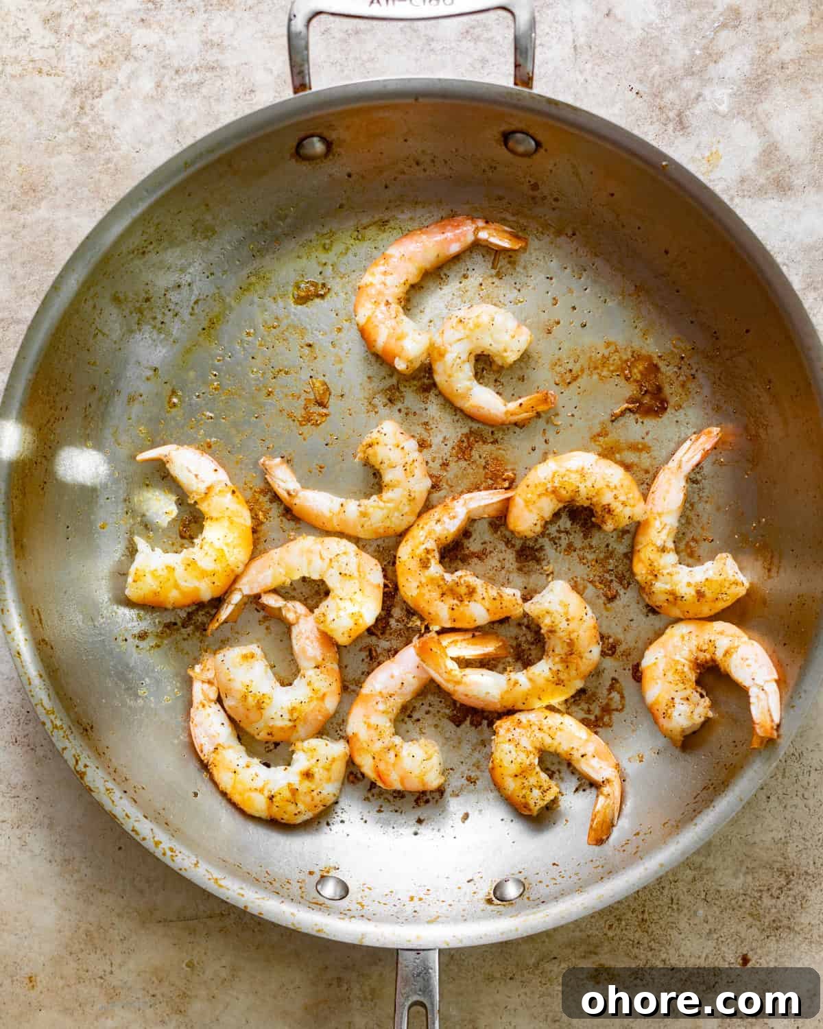 Cajun Shrimp and Creamy Cheddar Grits Recipe 5 seared shrimp in a skillet.
