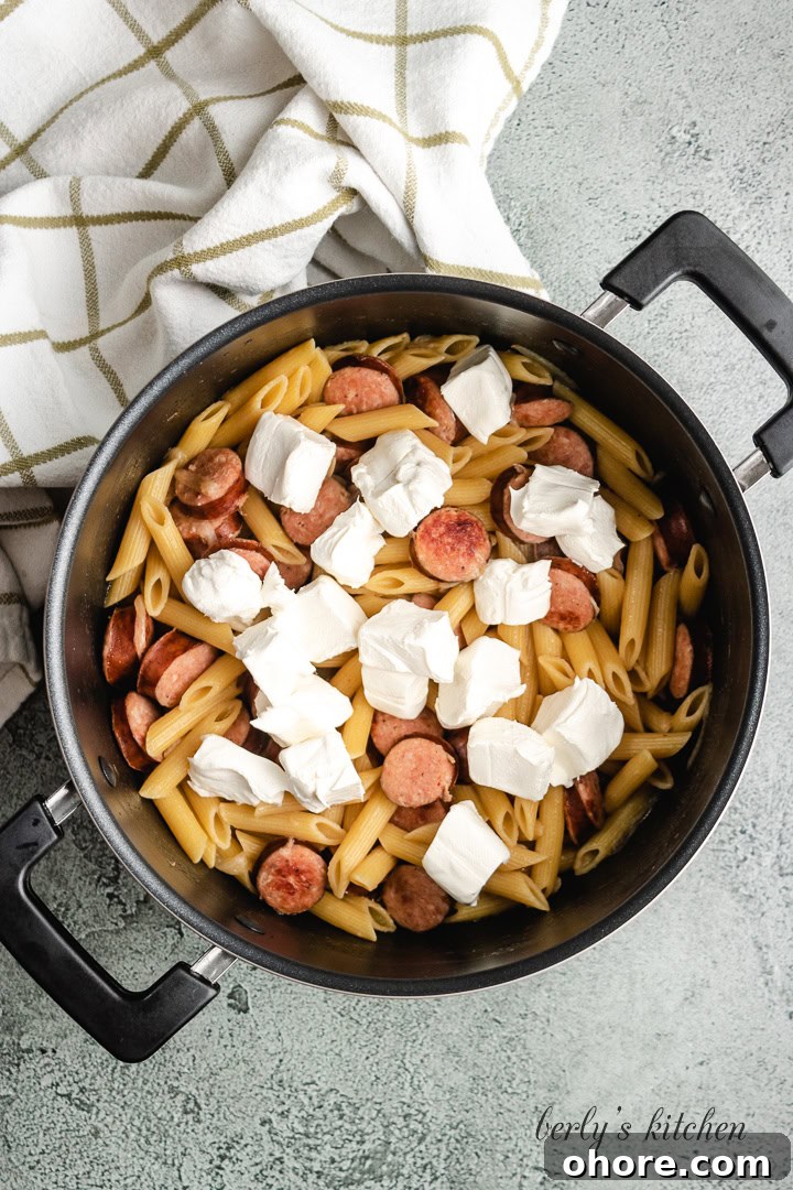 Creamy Kielbasa Pasta Recipe with Garlic Parmesan Sauce 5 Cubed cream cheese added to the cooked noodles.