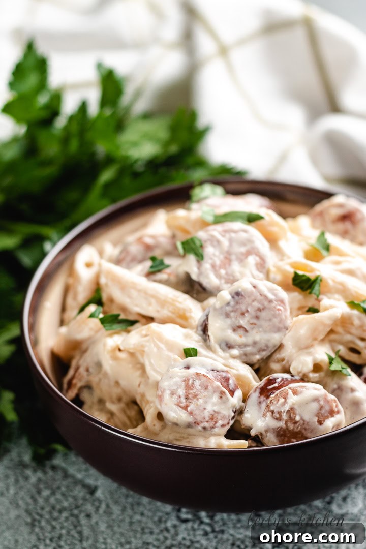 Creamy Kielbasa Pasta Recipe with Garlic Parmesan Sauce 7 The creamy one-pot pasta served in a brown bowl.