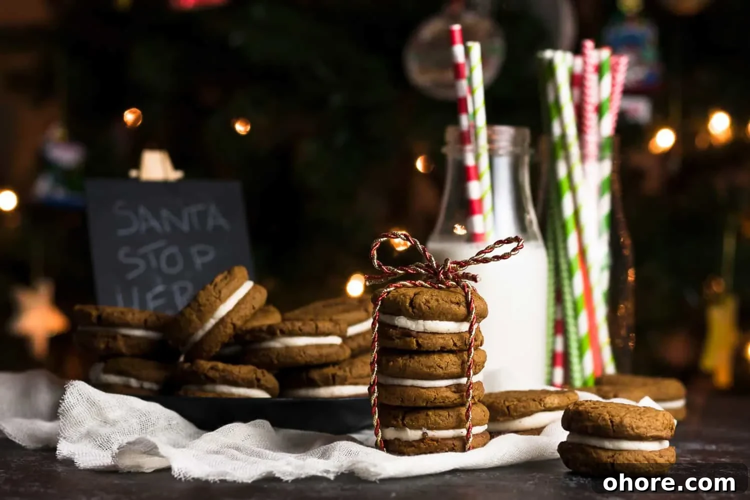 Gingerbread eggnog sandwich cookies on a plate, showing the creamy filling.