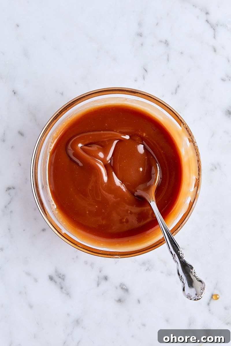 Salted caramel sauce in glass bowl with spoon