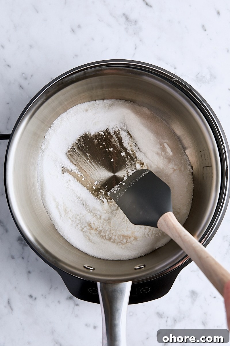 Granulated sugar heated in light-colored saucepan and beginning to melt