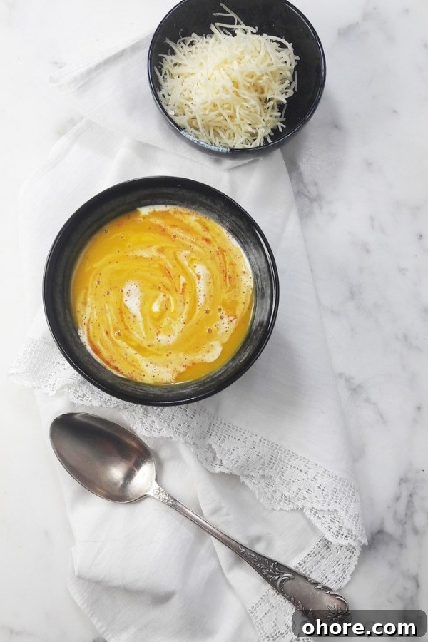 Authentic French Pumpkin Soup Recipe — Creamy Velouté for Fall 3 French pumpkin soup with grated emmental cheese and a white and marble background
