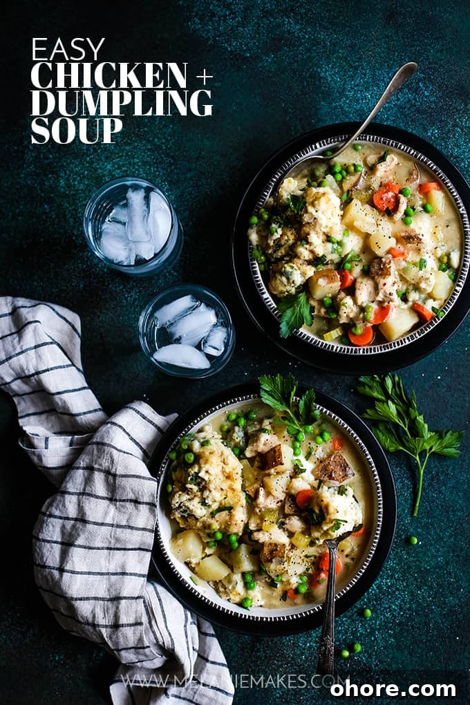 Easy Chicken and Dumpling Soup Two bowls of Easy Chicken and Dumpling Soup sit on a speckled green surface alongside a striped napkin, two glasses of ice water and a sprig of parsley.