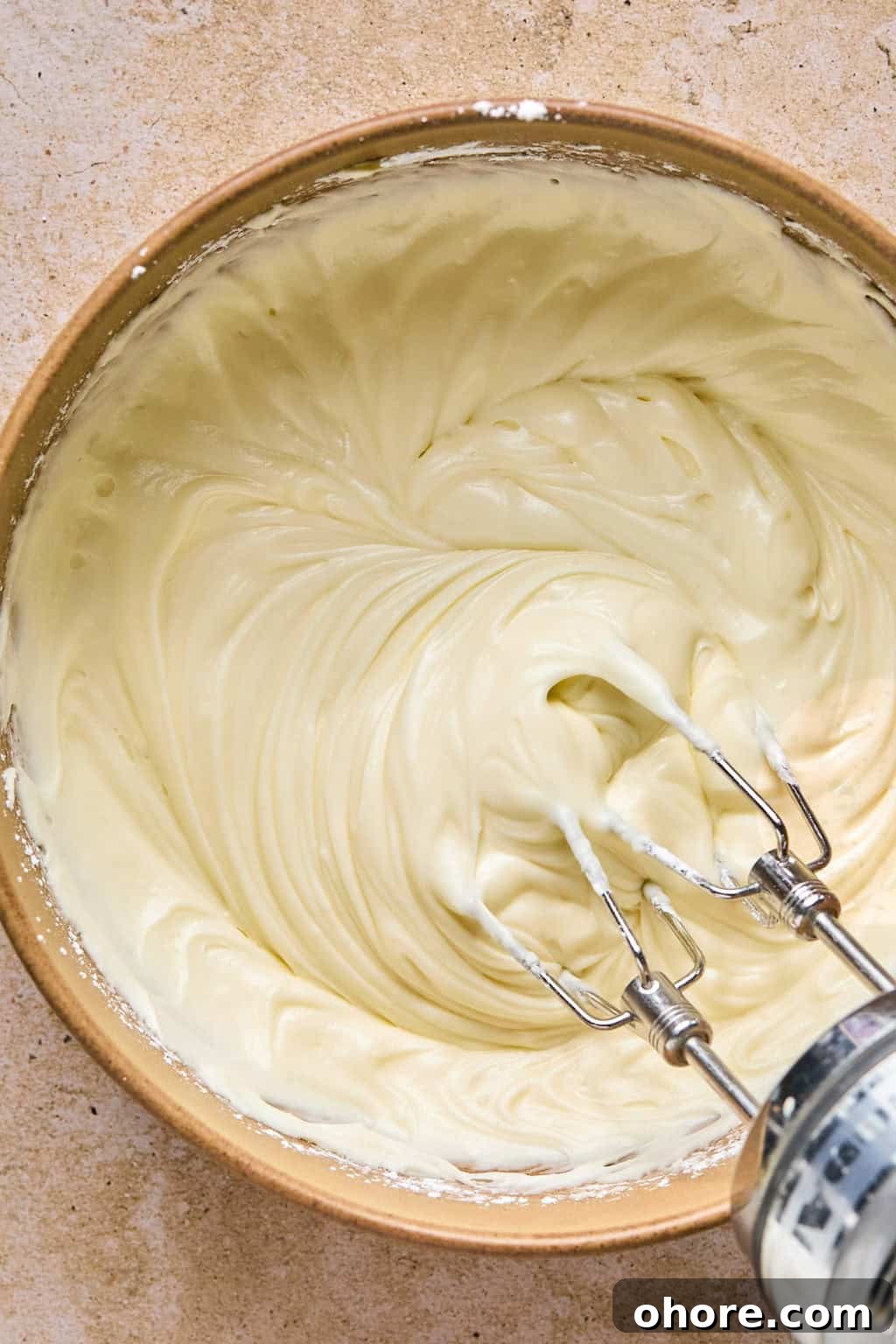 Pumpkin Spice Molasses Cookies Recipe for Cozy Fall Baking 14 Maple cream cheese frosting in mixing bowl with electric mixer.