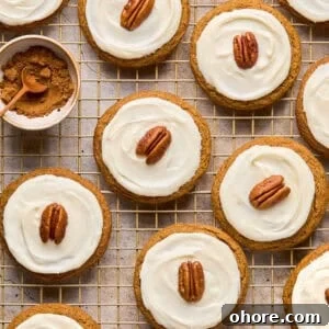 Pumpkin Spice Molasses Cookies Recipe for Cozy Fall Baking 17 Iced molasses cookies with pecan half on top arranged on cooling rack.