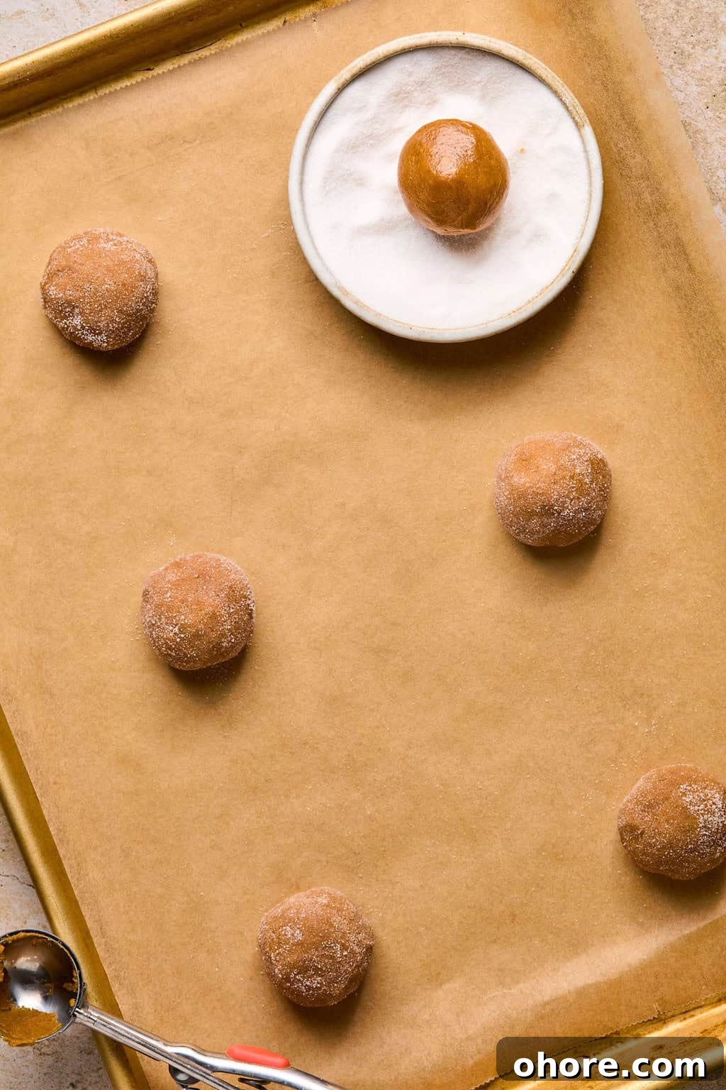 Pumpkin Spice Molasses Cookies Recipe for Cozy Fall Baking 9 Rolled pumpkin spice cookies on parchment before baking.