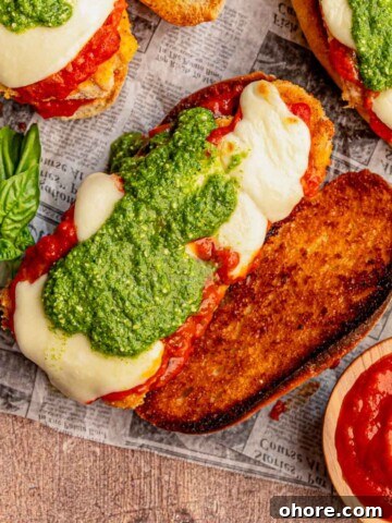Chicken parmesan sandwich topped with pesto.