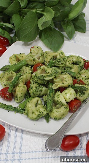 Cheese tortellini, aspargus spears, and halved tomatoes smothered in pesto.