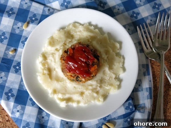 Meatloaf Cupcakes Topped with Creamy Mashed Potato Frosting 5 Spinach and Pine Nut Meatloaf Muffin on top of plate of mashed potatoes