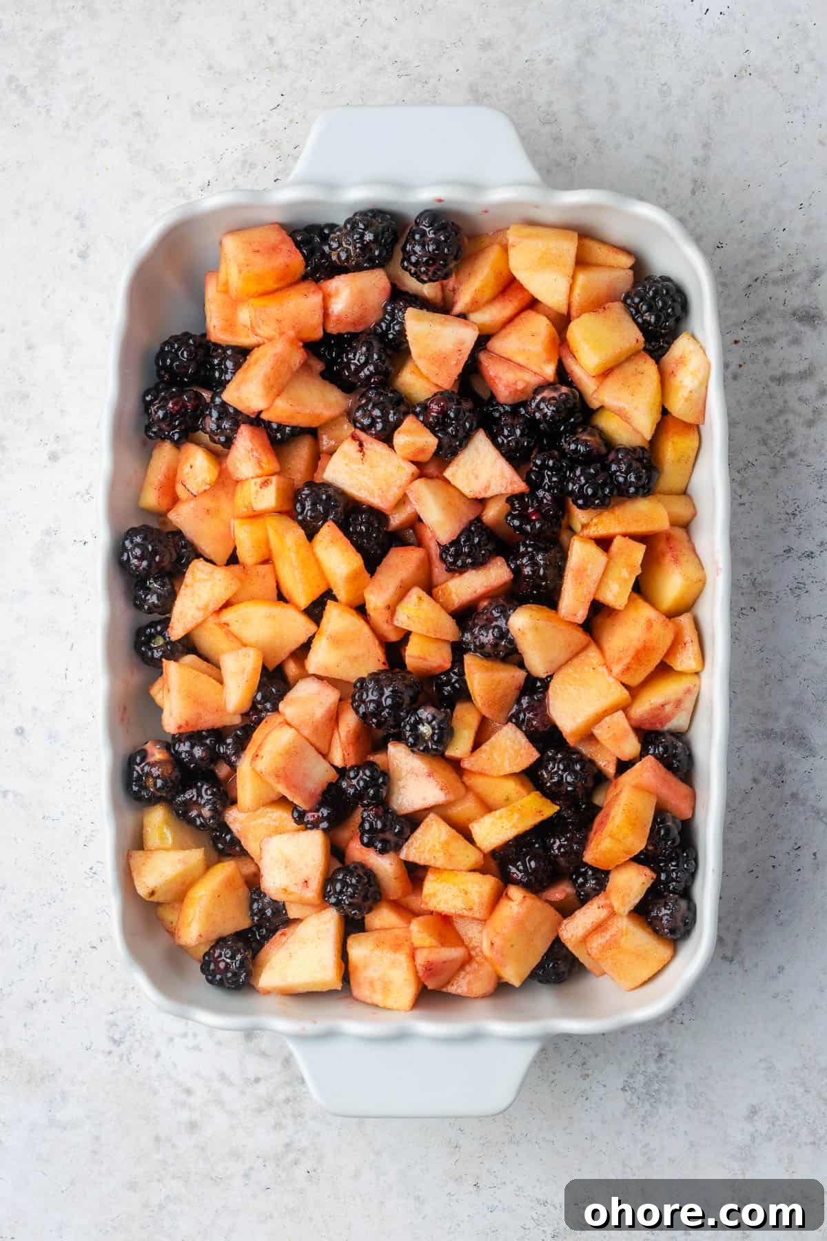 Apple & Blackberry Crumble Recipe: Rustic Autumn Dessert 6 Fruit mixture spread in a casserole dish.