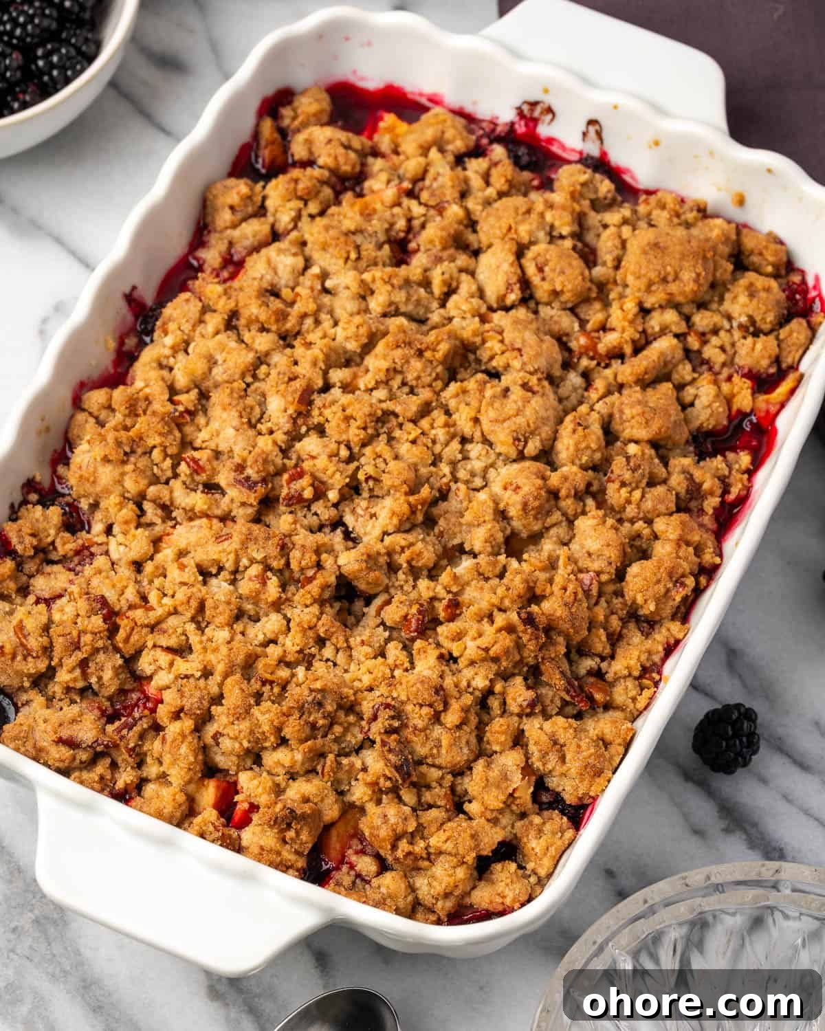 Apple & Blackberry Crumble Recipe: Rustic Autumn Dessert 8 A freshly baked apple and blackberry crumble sitting on a marble counter.