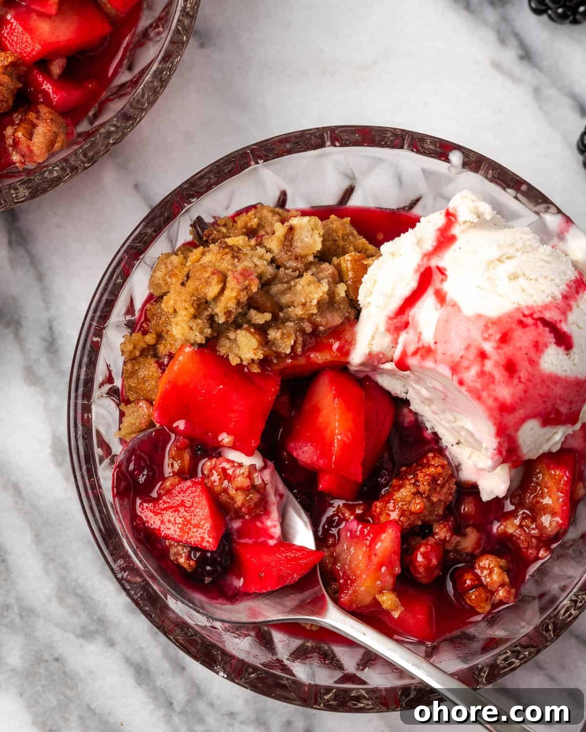 Apple & Blackberry Crumble Recipe: Rustic Autumn Dessert 9 A spoon scooping up a bite of apple blackberry crumble with vanilla ice cream.