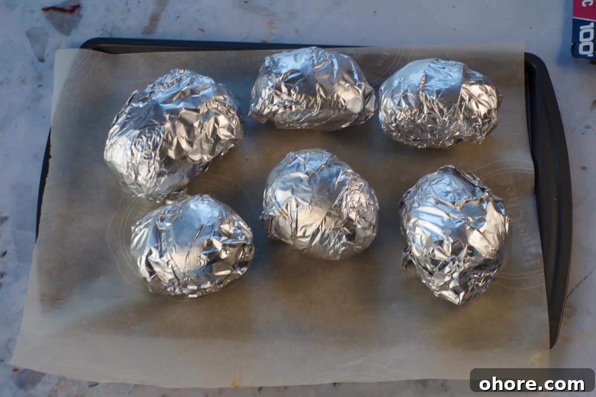 Crispy Baked Potatoes with Onion Soup Mix Seasoning 7 6 Potatoes wrapped in foil on a parchment lined baking sheet