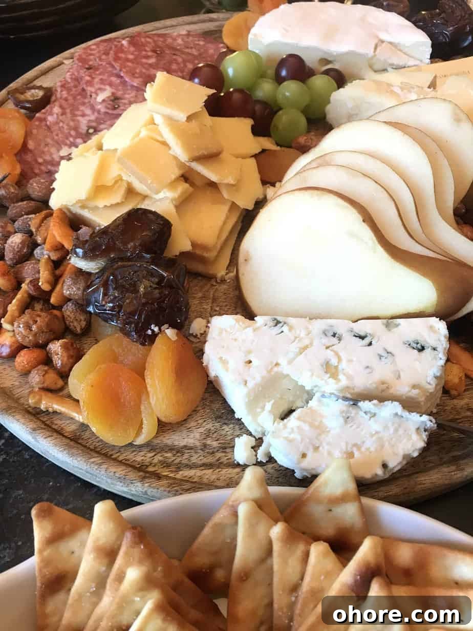 Charcuterie board loaded with cheeses, fruits, nuts and meats.