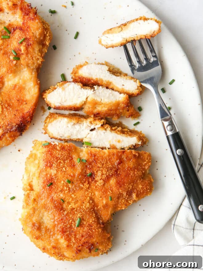 Crispy Oven-Fried Chicken Recipe: Juicy, Golden, and Tender 3 sliced oven fried chicken with fork
