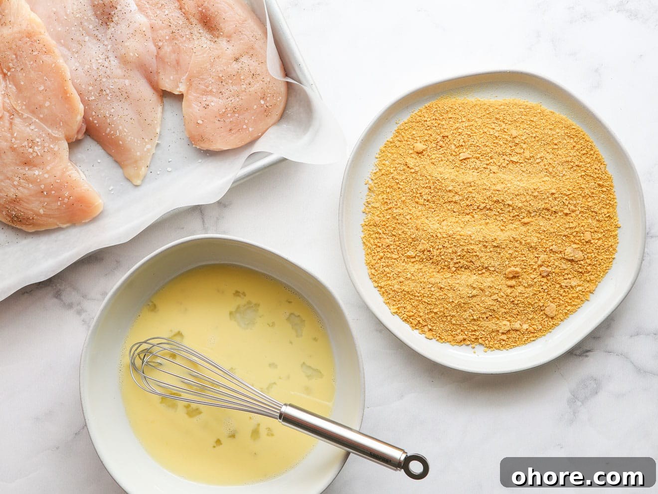 chicken ready with whisked egg and cornflake crumbs